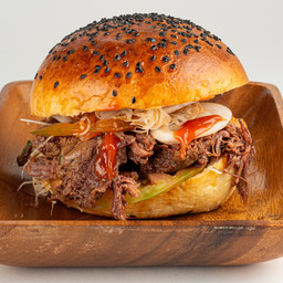 Panino Pulled Beef con cavolo cappuccino fresco, cipolla rossa, pomodoro e salse 